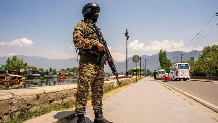 Armed Indian soldier stands guard on a street in Kashmir amid heightened security.