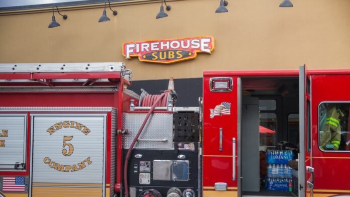 Firehouse Subs hosts 'Touch-the-Truck' event with a fire truck parked outside the restaurant, engaging families and children.